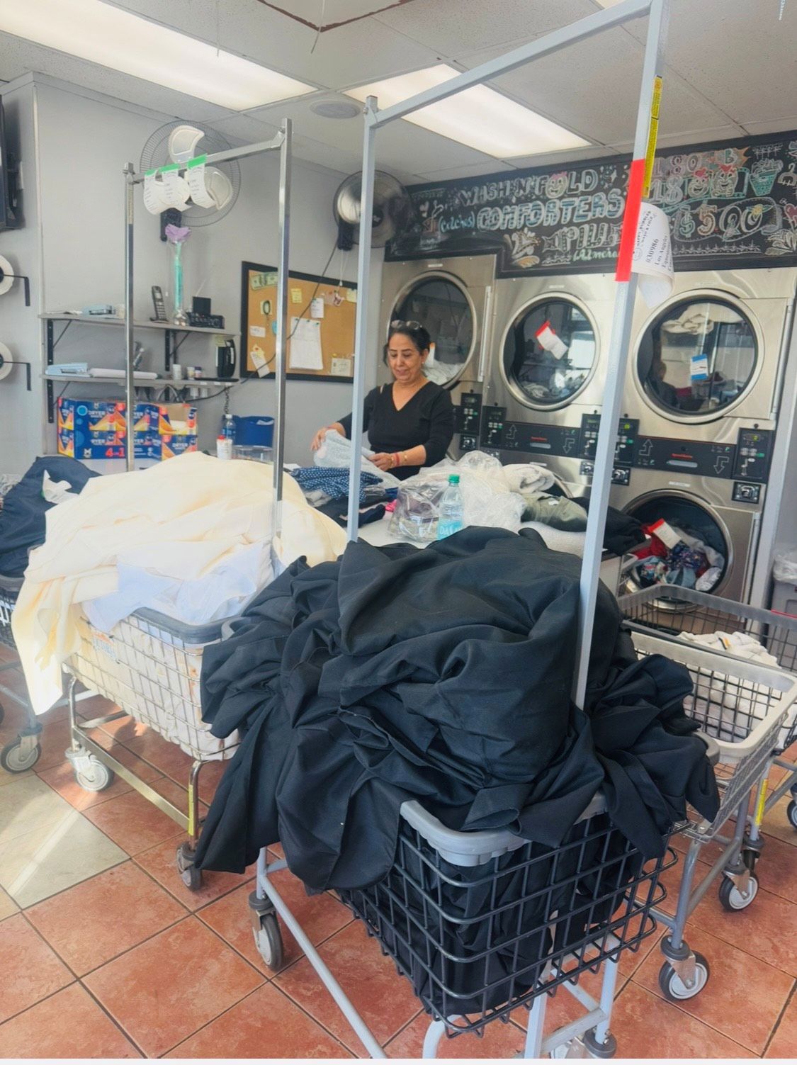 Lady arranging washed laundry at Happy Bubbles Laundromat, North Hollywood.